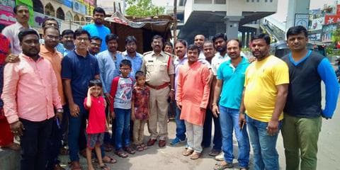 Volunteers and a police officer at the opening of a roadside drinking water kiosk
